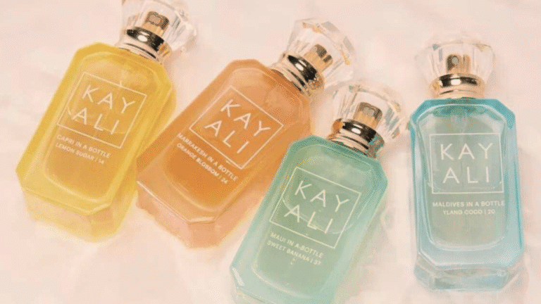 Flaconi colorati dei profumi KAYALI Vacay in a Bottle in formato full-size: Capri, Marrakesh, Maui e Maldives, disposti su sfondo chiaro