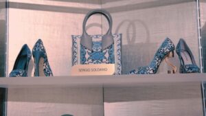 Scarpe e borsa Sergio Soldano con motivo decorativo esposte su una mensola