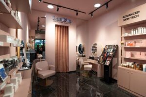 Interno del nuovo Lameem Innovative Skin Studio di Milano con arredi rosa cipria, postazioni beauty illuminate, prodotti skincare esposti e area dedicata alla tecnologia avanzata per l’analisi della pelle.