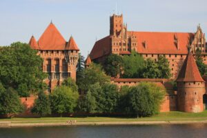 Castello di Malbork in Polonia, imponente fortezza medievale in mattoni rossi dei Cavalieri Teutonici affacciata sul fiume Nogat.