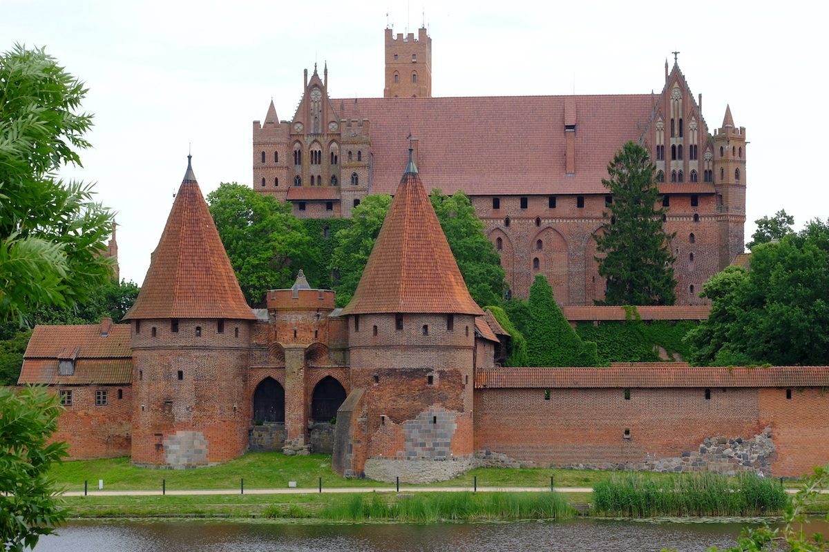 Castello di Malbork in Polonia, imponente fortezza medievale in mattoni rossi dei Cavalieri Teutonici affacciata sul fiume Nogat.